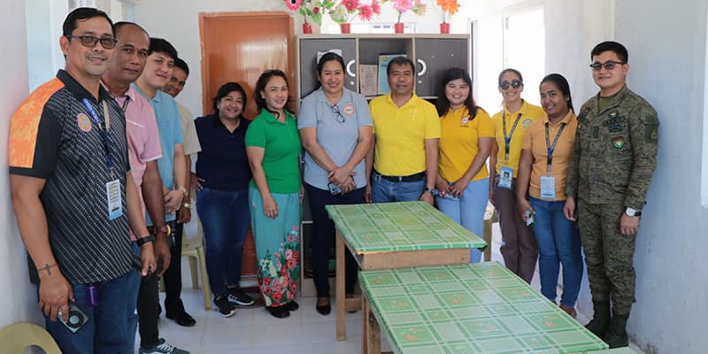 LGU functionaries, DILG officials and staff, and 1LT Pepino pose for a group photo inside the health center